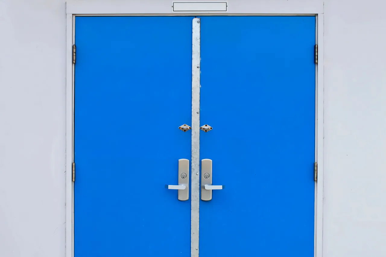 Porta a doppio battente blu con maniglie argentate