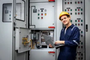 Tecnico con laptop davanti a quadro elettrico industriale