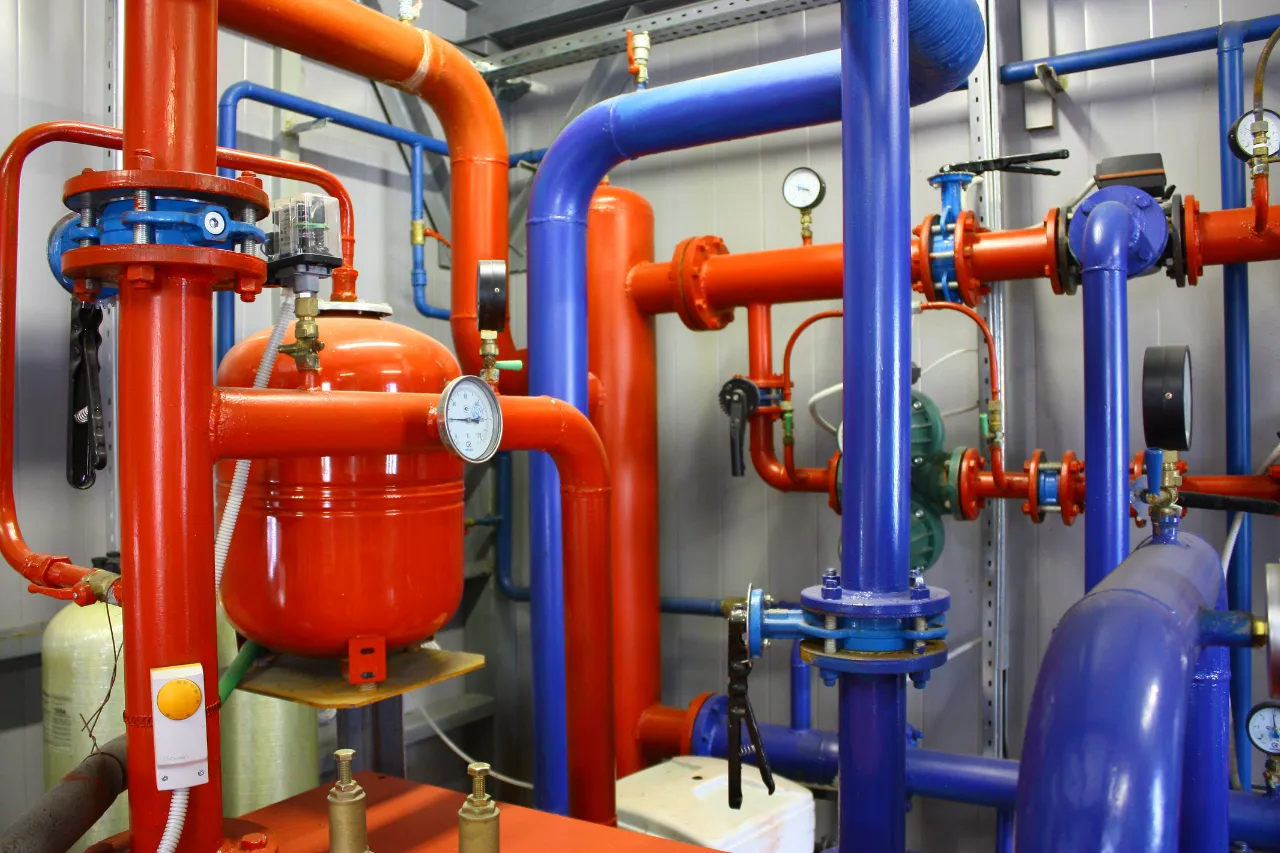 Impianto idraulico industriale con tubazioni rosse e blu