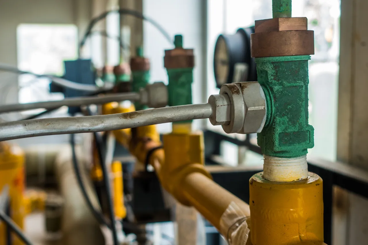 Valvole industriali verdi e tubature gialle in primo piano