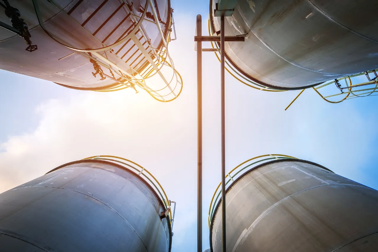 Serbatoi industriali metallici ripresi dal basso contro il cielo
