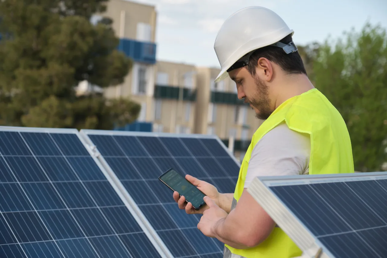 Tecnico controlla pannelli solari con smartphone