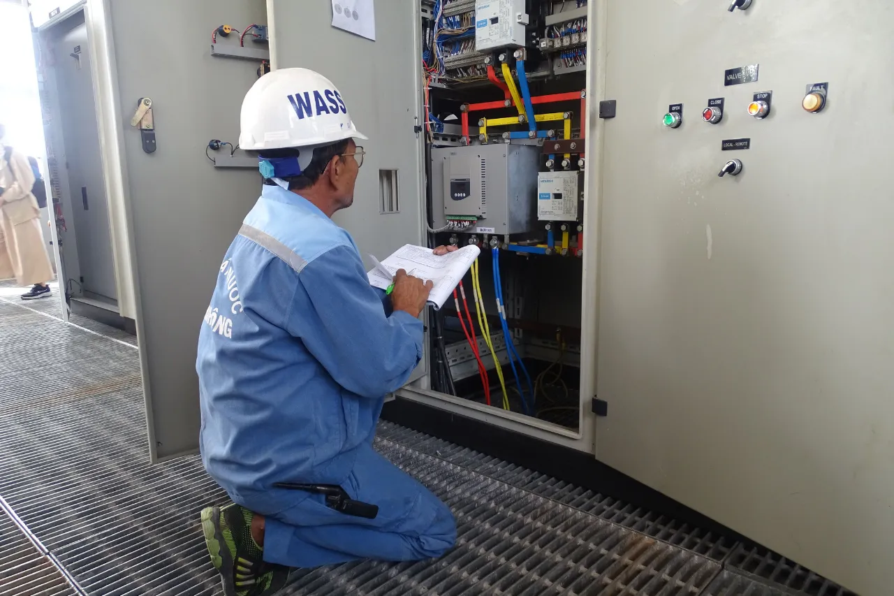 Tecnico controlla quadro elettrico industriale aperto