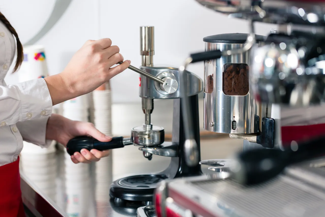 Barista macina caffè con macinacaffè professionale