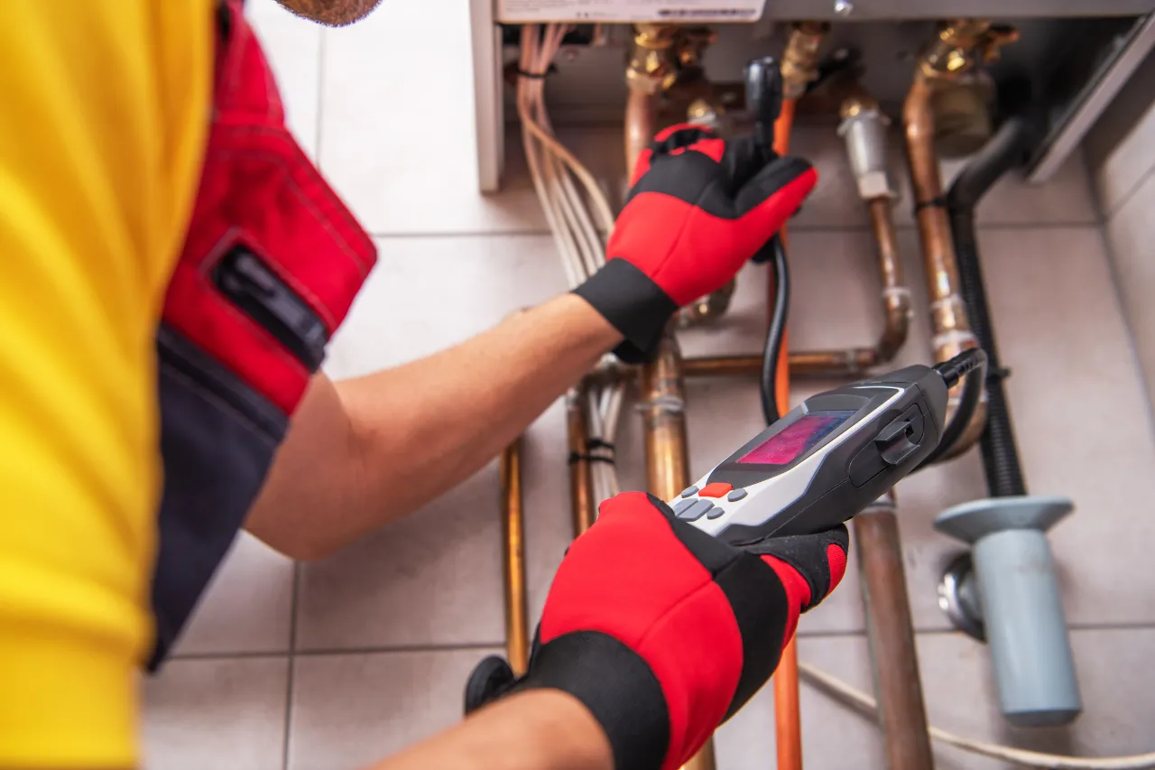 Tecnico controlla caldaia con strumento diagnostico