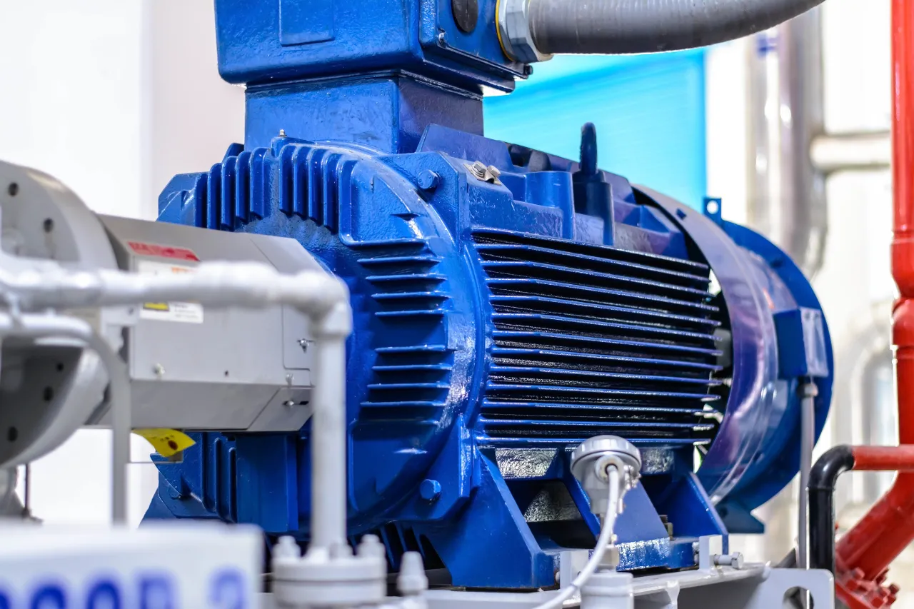 Motore elettrico industriale blu con tubazioni e sensore