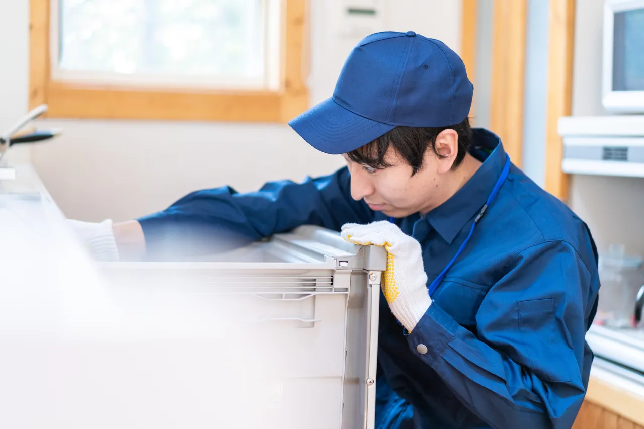 Tecnico ripara un elettrodomestico in cucina