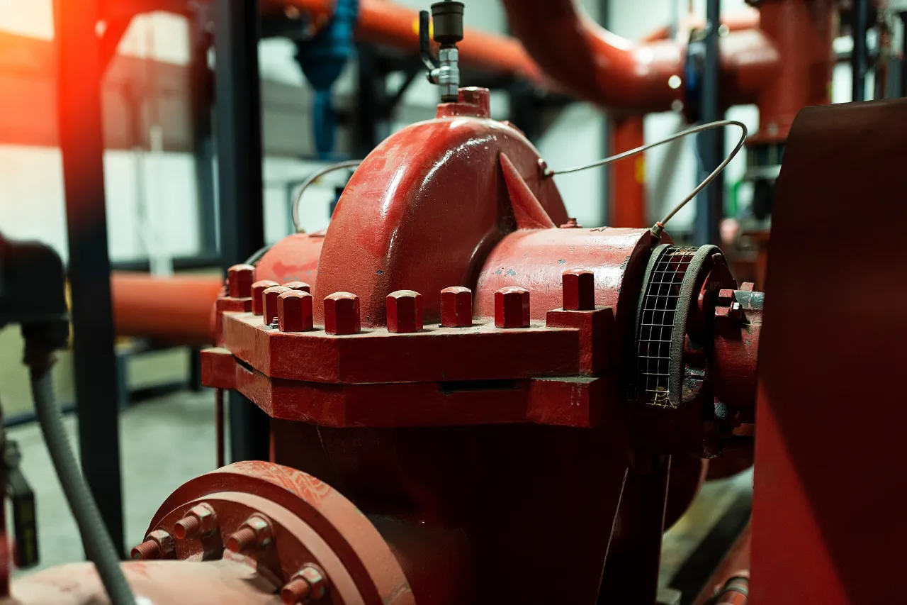 Valvola industriale rossa collegata a tubazioni