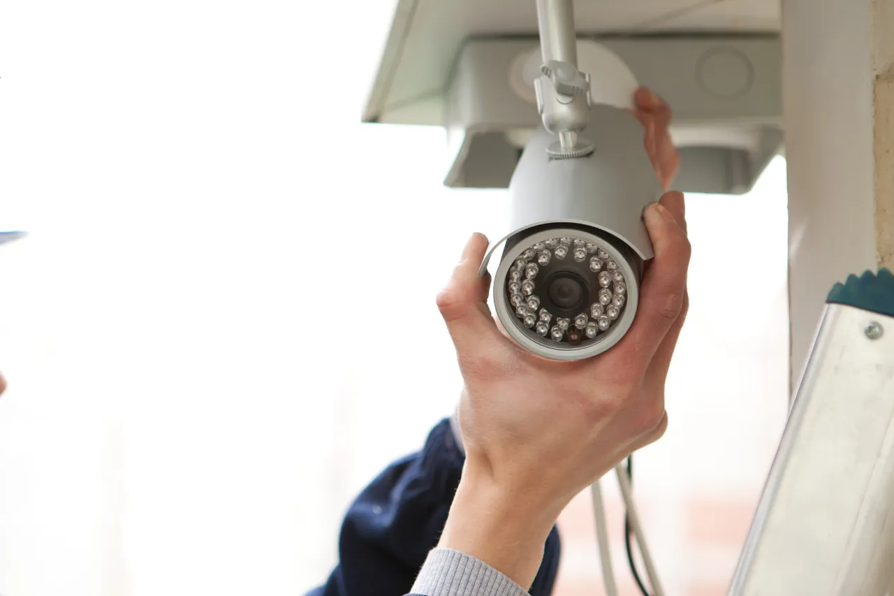 Tecnico installa una telecamera di videosorveglianza a soffitto