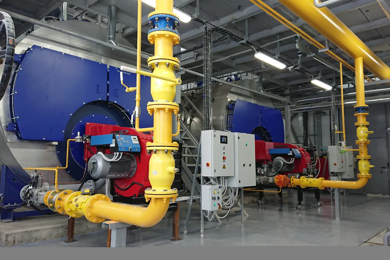 Impianto industriale con tubazioni gialle e caldaie blu