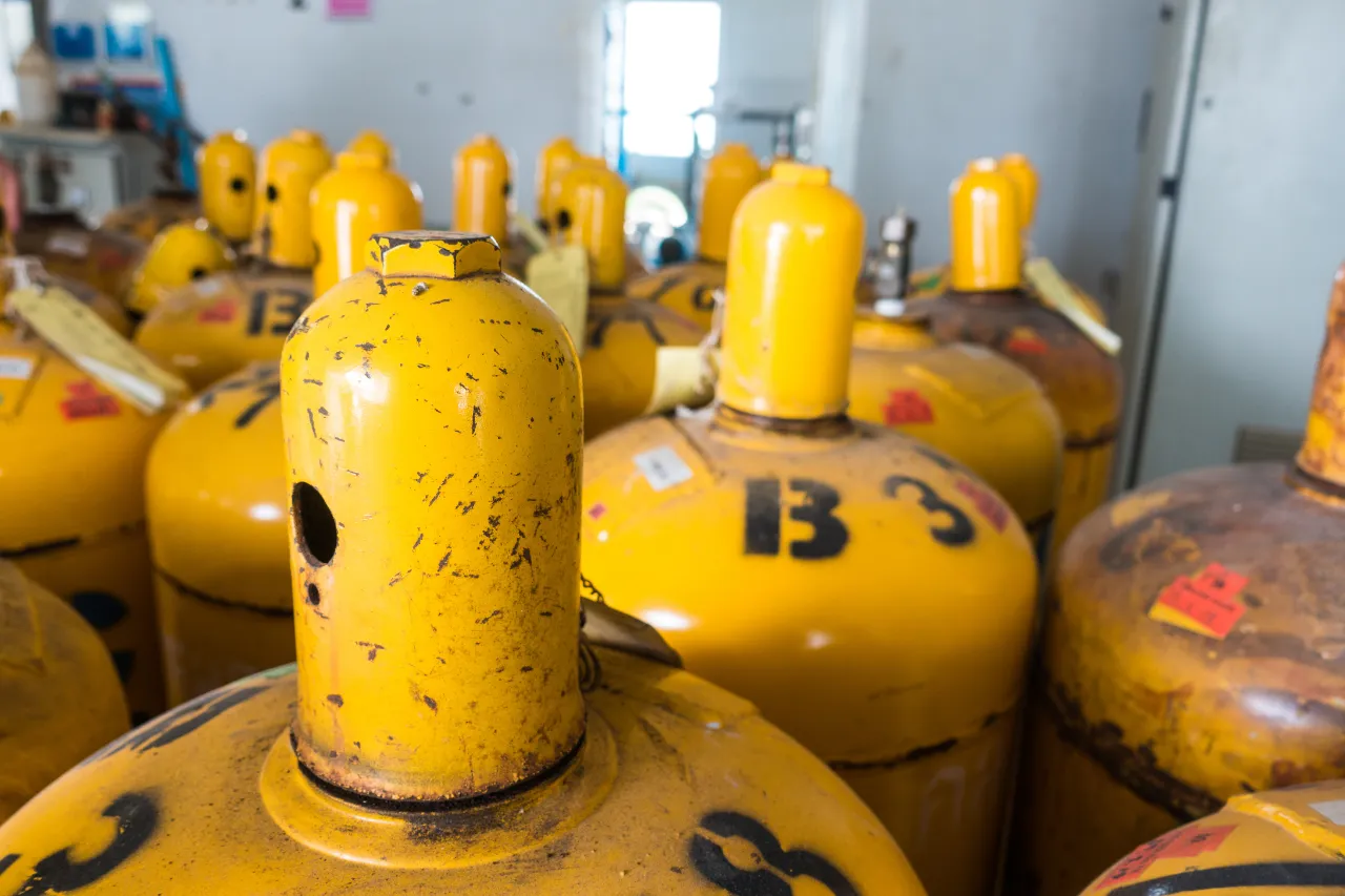 Bombole gialle di gas accatastate in un deposito