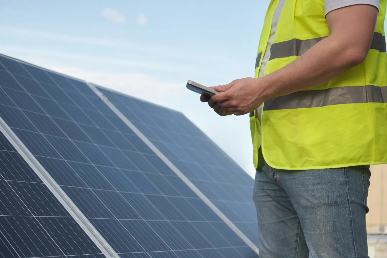 Tecnico controlla pannelli solari con smartphone