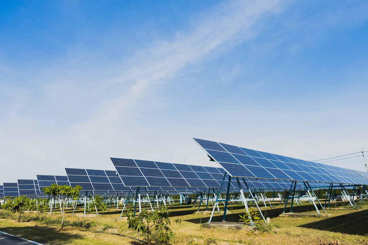 Impianto fotovoltaico con pannelli solari sotto cielo azzurro
