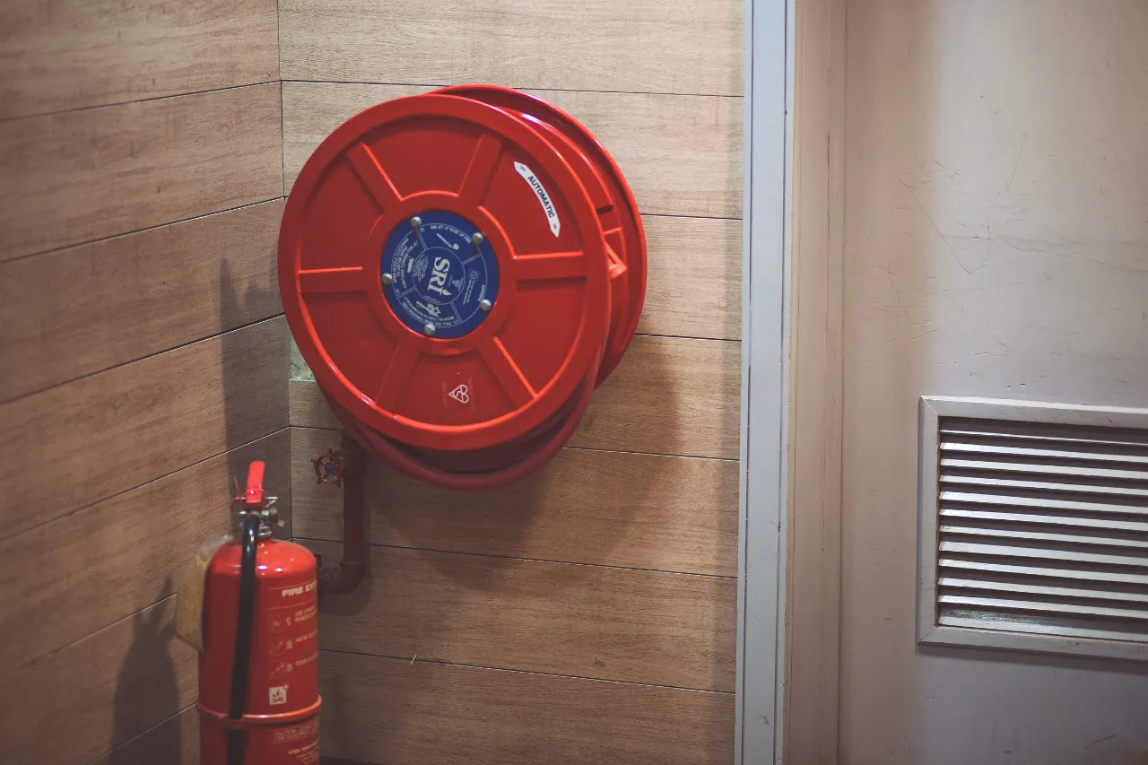 Naspo antincendio rosso e estintore su parete interna