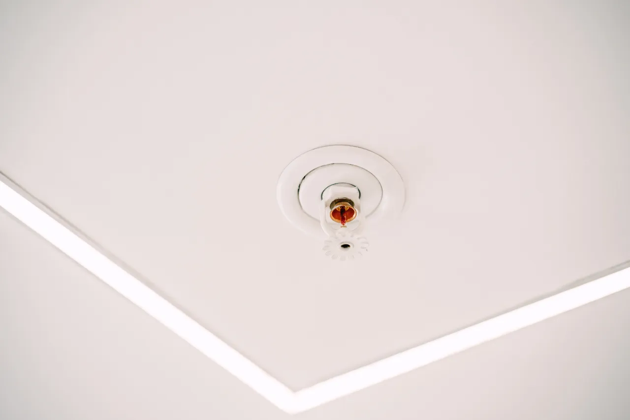 Testina sprinkler antincendio installata sul soffitto bianco