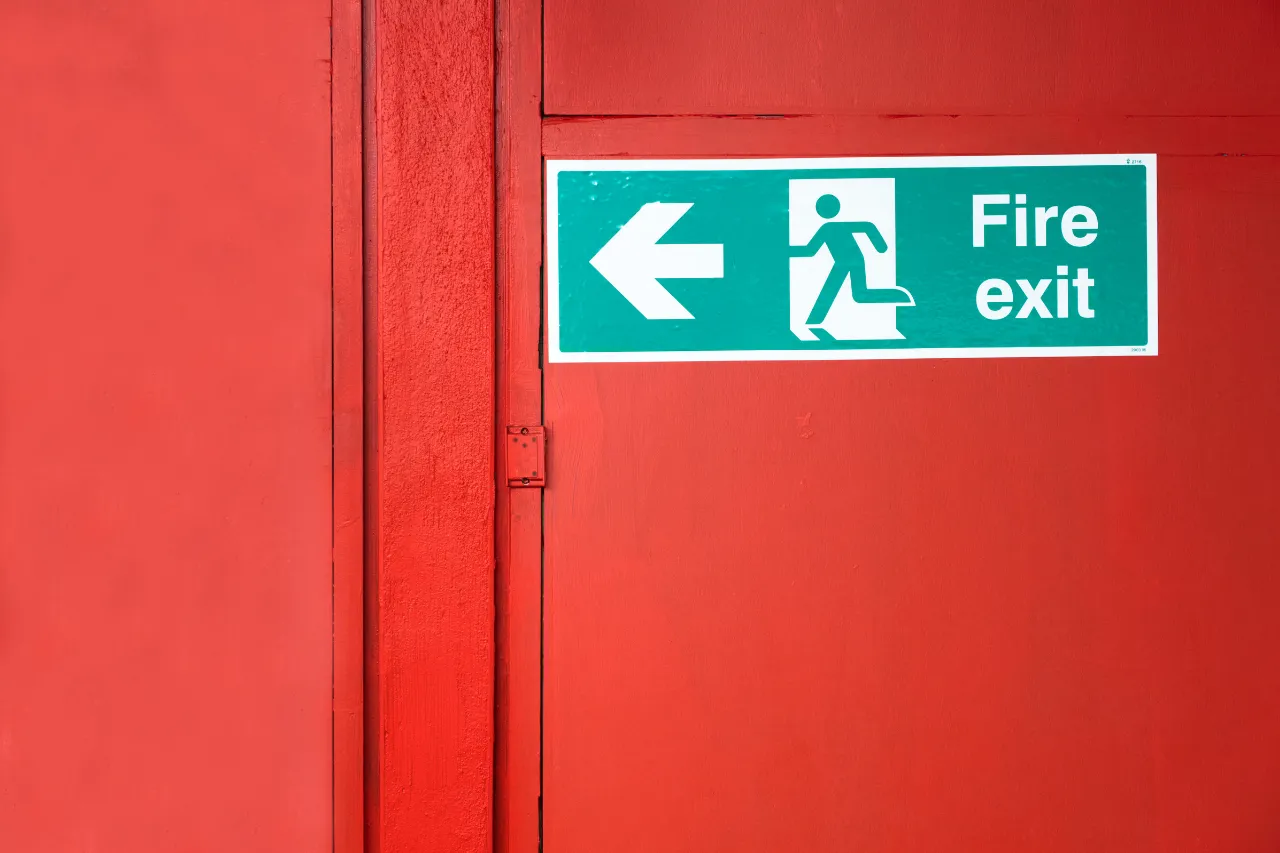 Segnale uscita antincendio su porta rossa