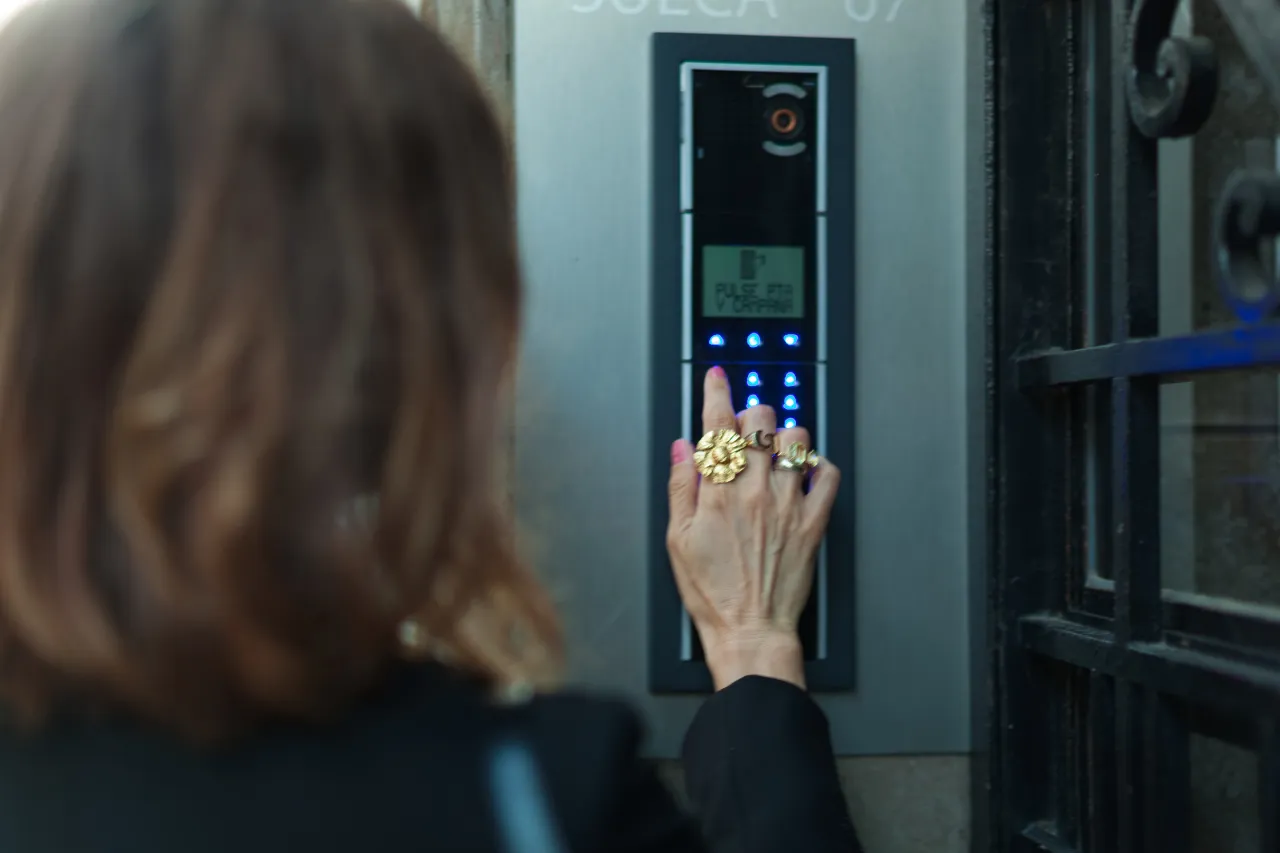 Donna digita codice su citofono elettronico