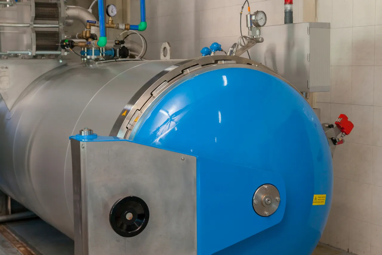 Grande serbatoio industriale blu con manometri e tubazioni