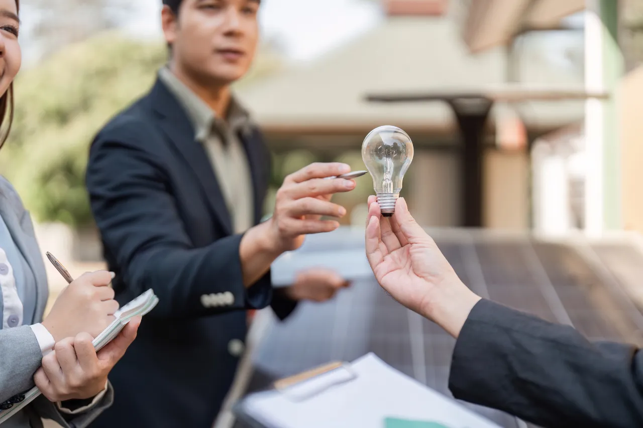 Professionisti discutono un’idea rappresentata da una lampadina