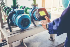 Tecnico controlla una pompa industriale con termocamera