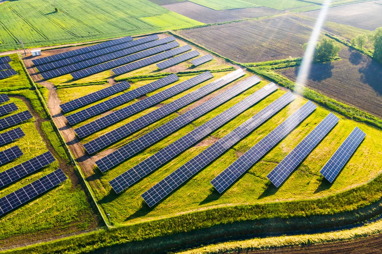 Impianto fotovoltaico tra campi agricoli visto dall’alto