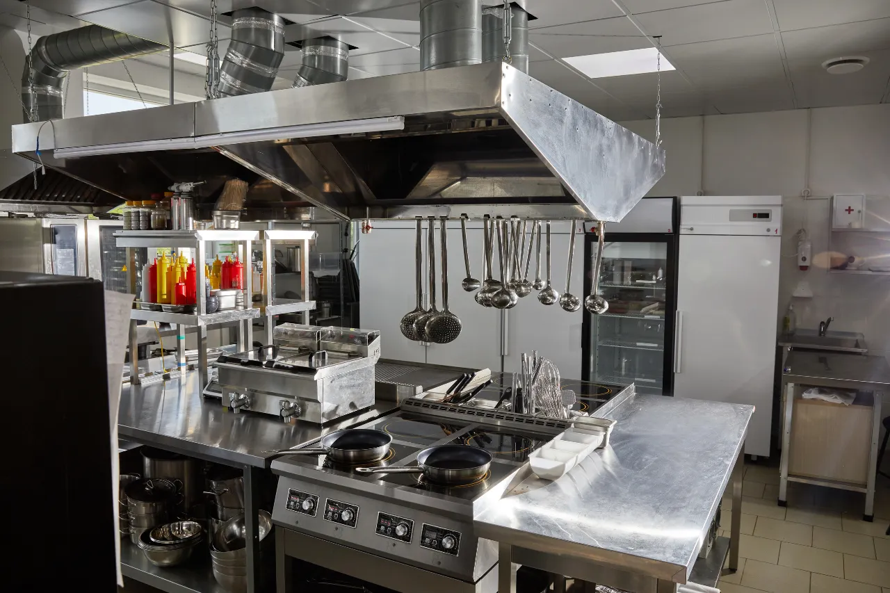 Cucina professionale in acciaio con cappa e utensili