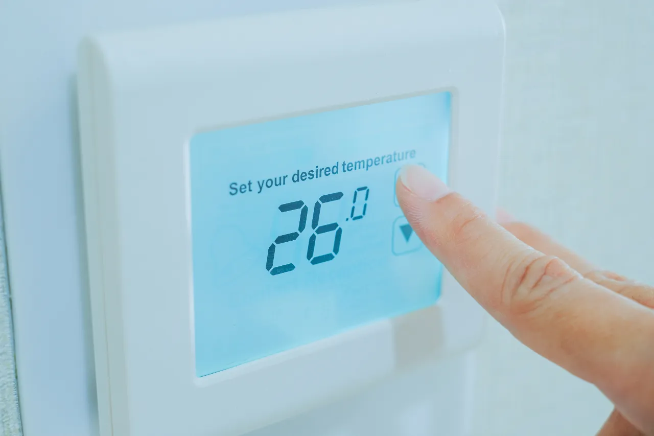 Mano regola termostato digitale a 26 gradi