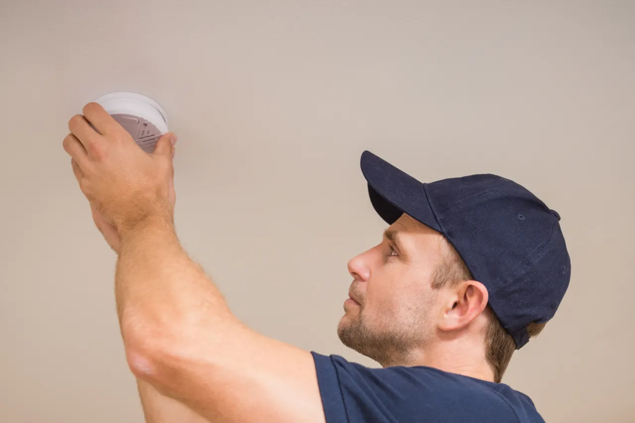 Tecnico installa un rilevatore di fumo sul soffitto