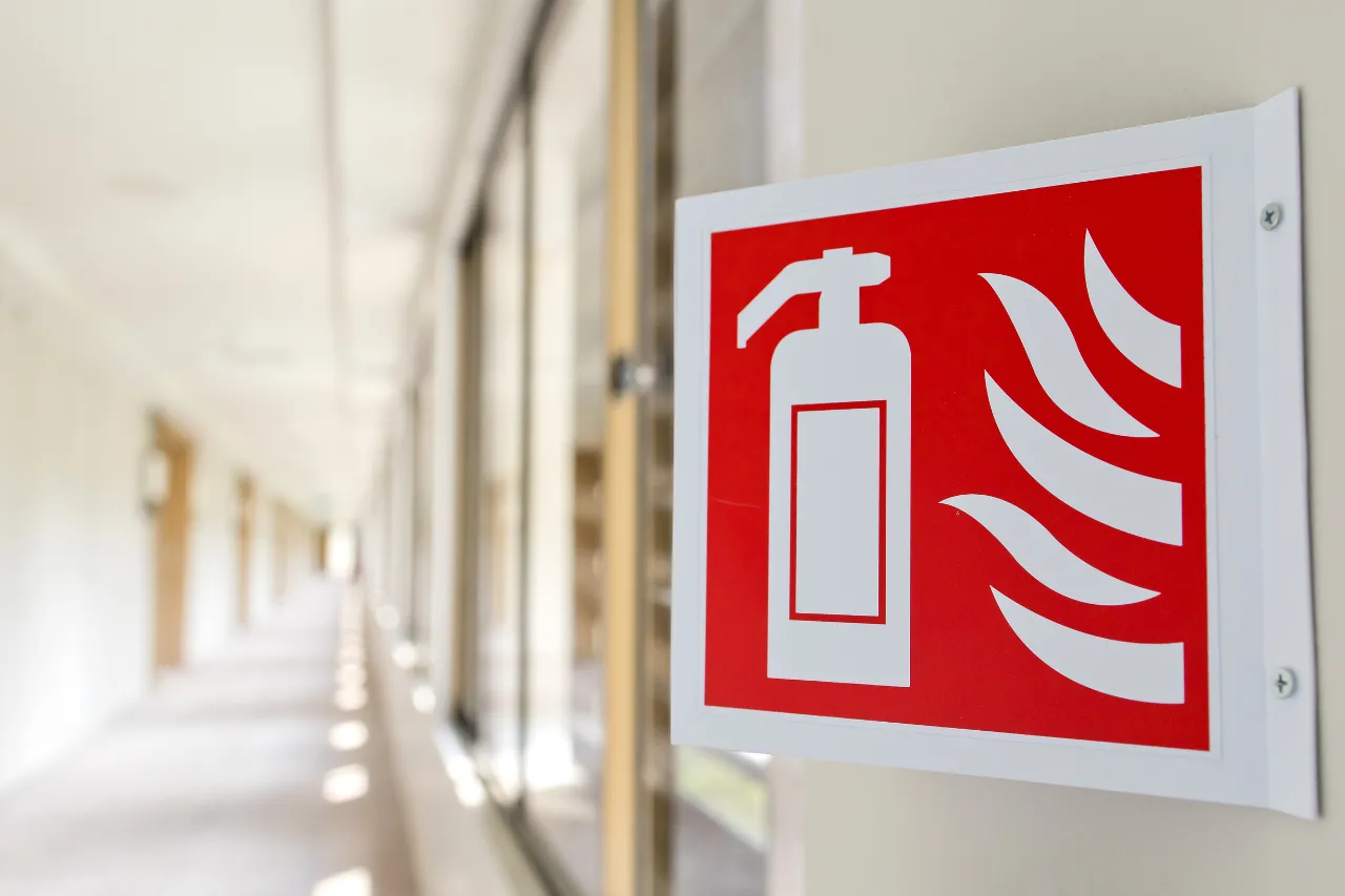 Segnale antincendio con estintore in un corridoio