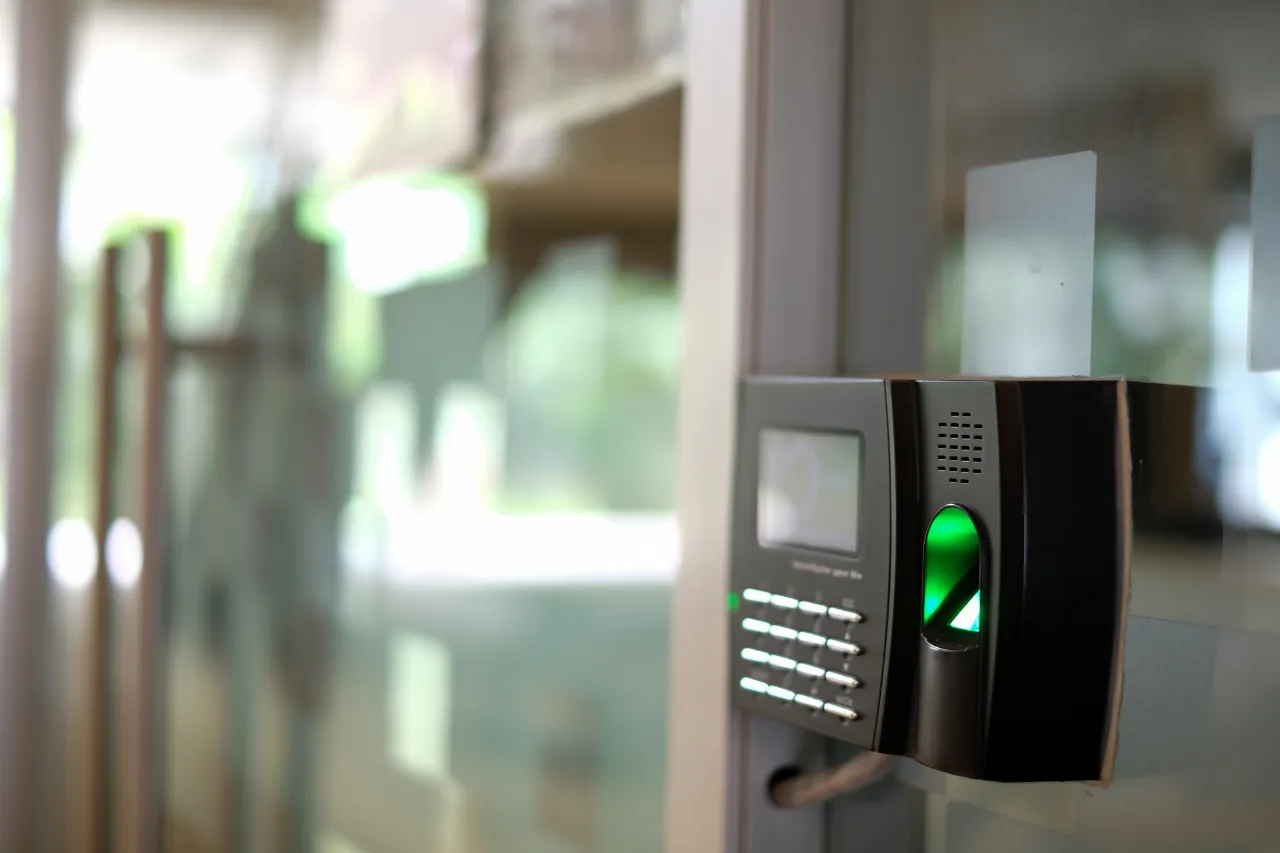 Lettore biometrico verde accanto a porta in vetro