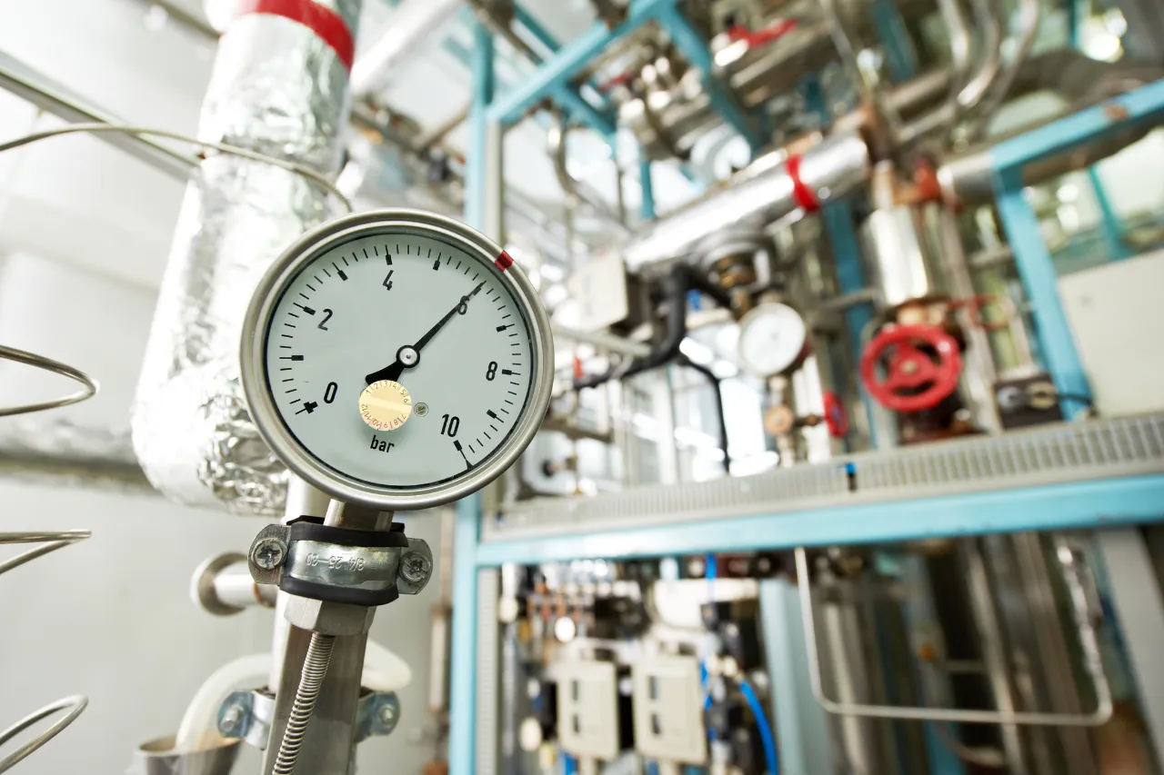 Manometro industriale collegato a tubazioni e valvole