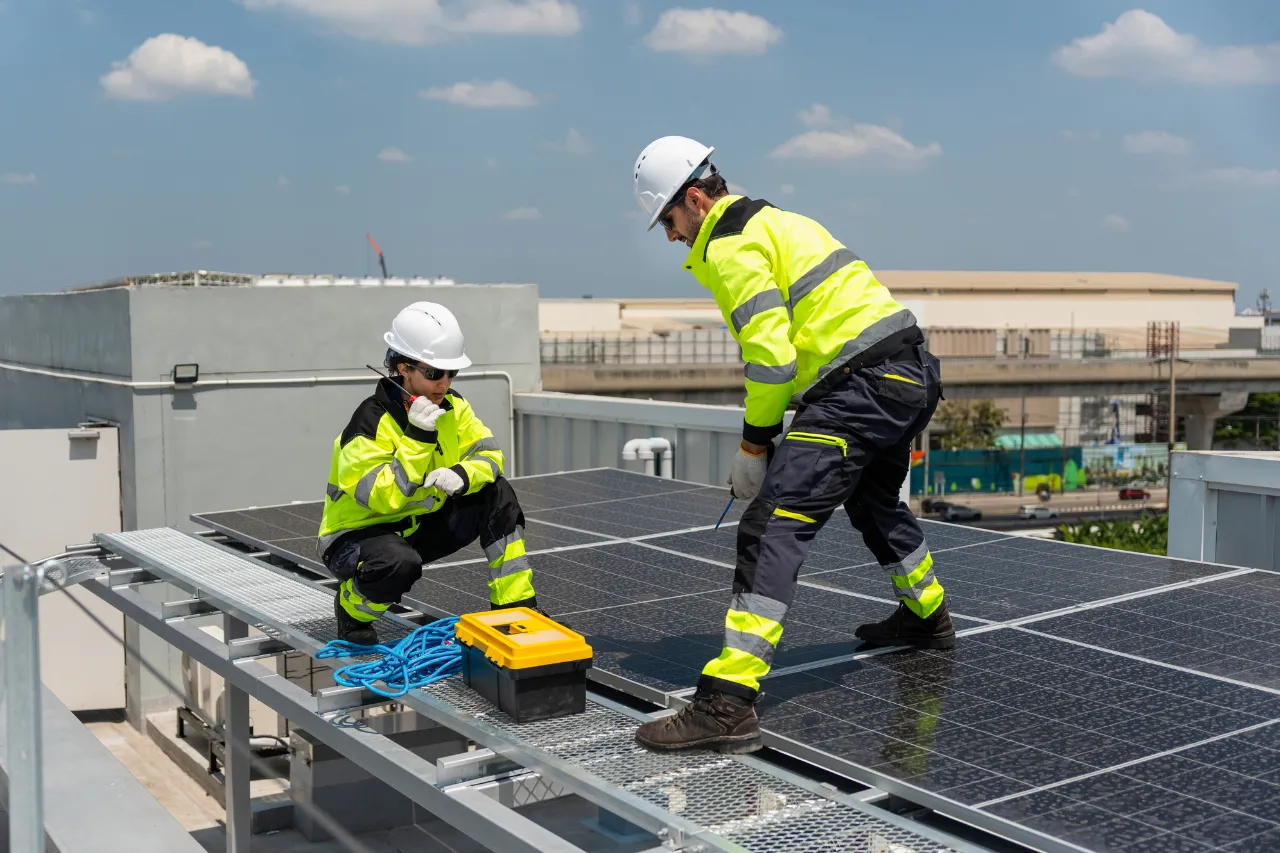 Tecnici installano pannelli solari su un tetto industriale