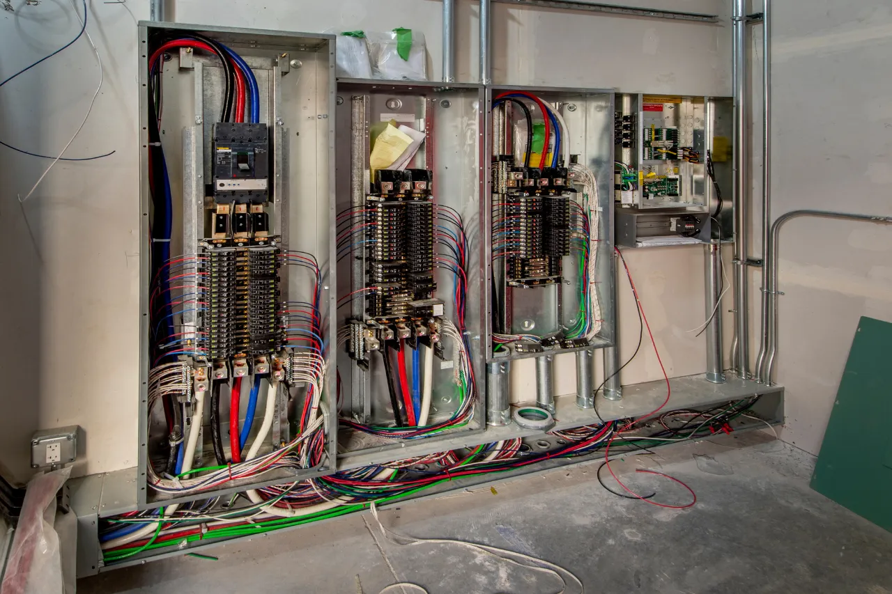 Quadri elettrici aperti con cablaggi multicolore in cantiere