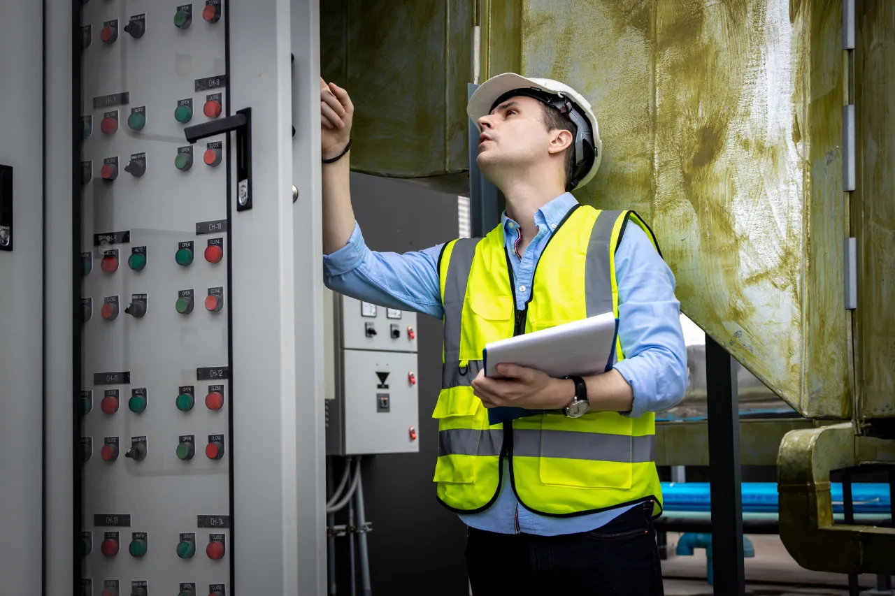 Tecnico controlla pannello elettrico in impianto industriale