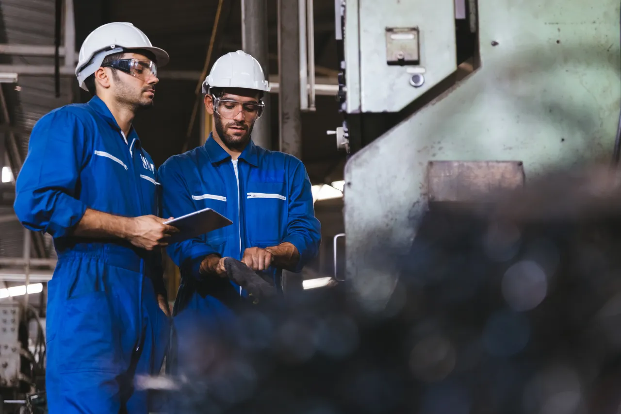Due operai controllano un macchinario industriale