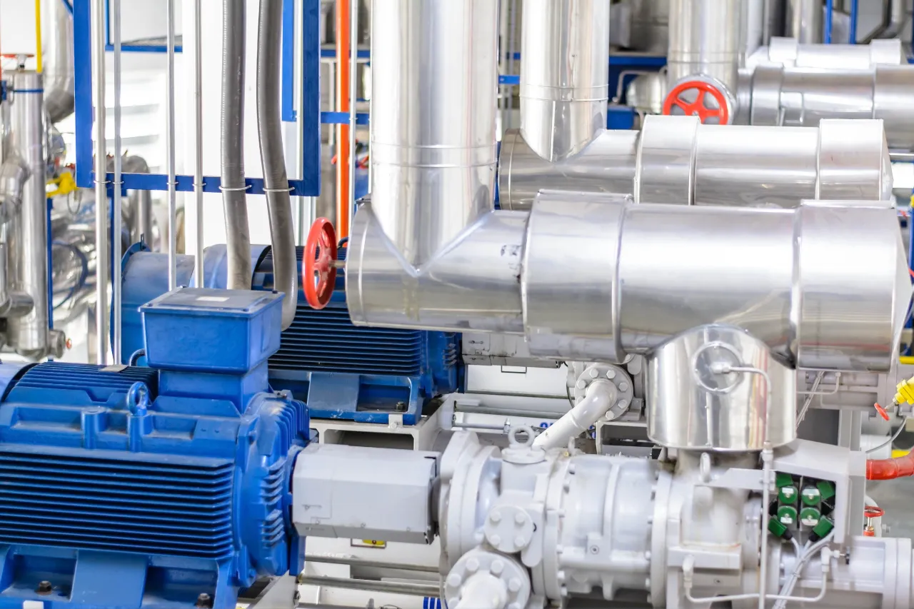 Macchinari industriali con tubazioni metalliche e motori blu