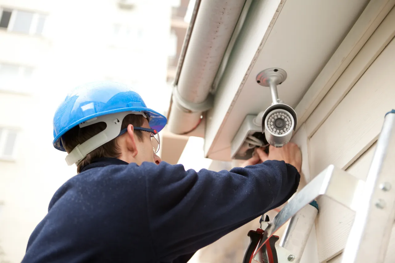 Tecnico installa una telecamera di sicurezza esterna