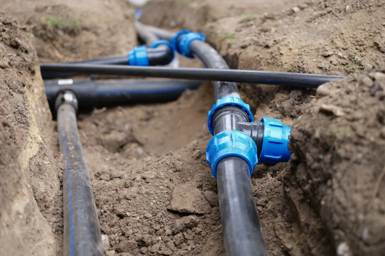 Tubi neri interrati con raccordi blu per irrigazione