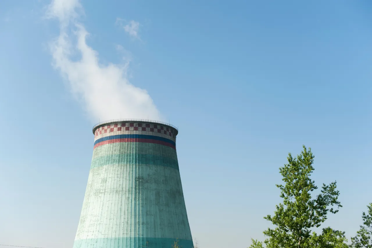 Torre di raffreddamento industriale sotto cielo azzurro
