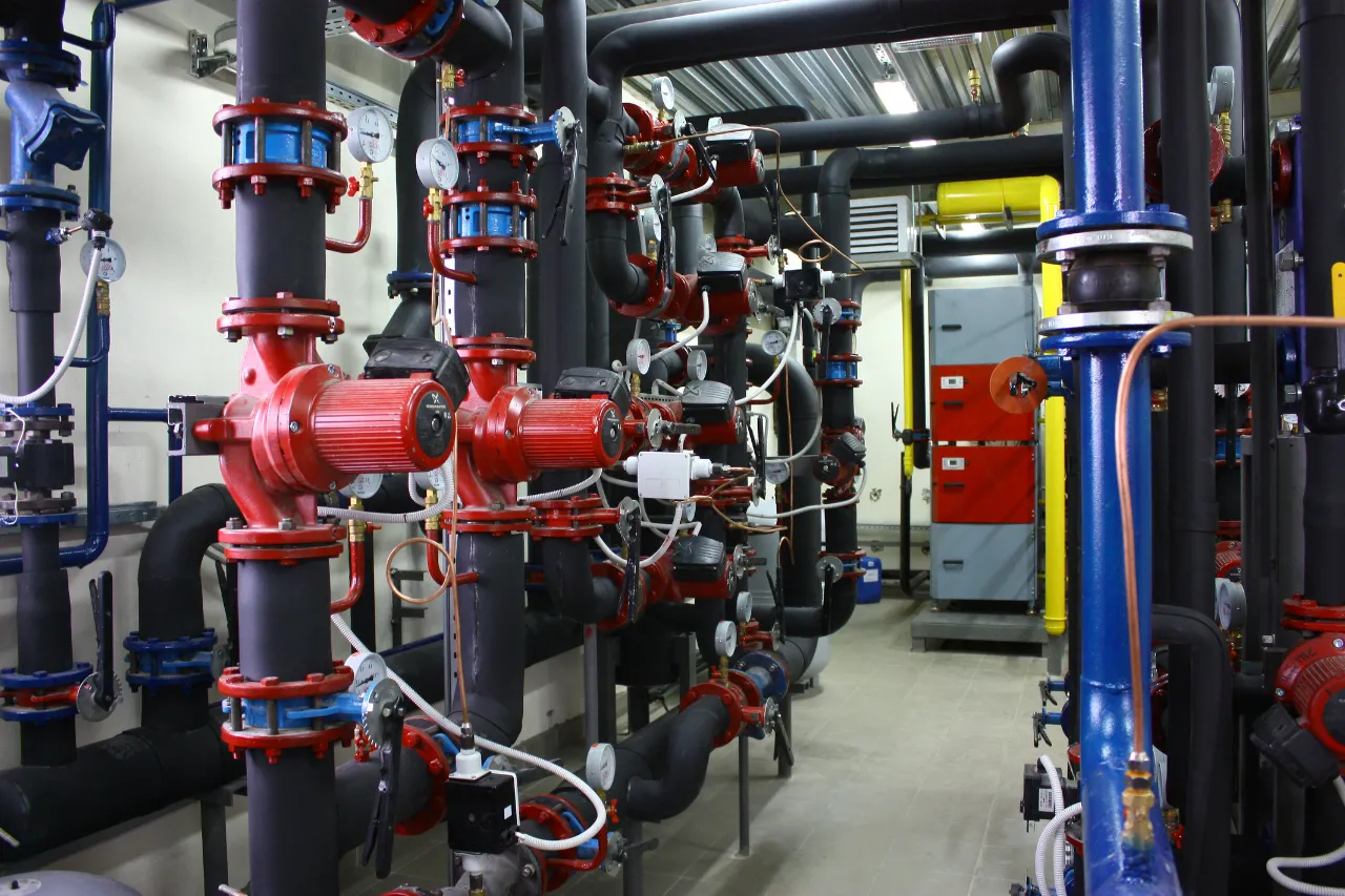 Impianto tecnico con pompe rosse e tubazioni isolate