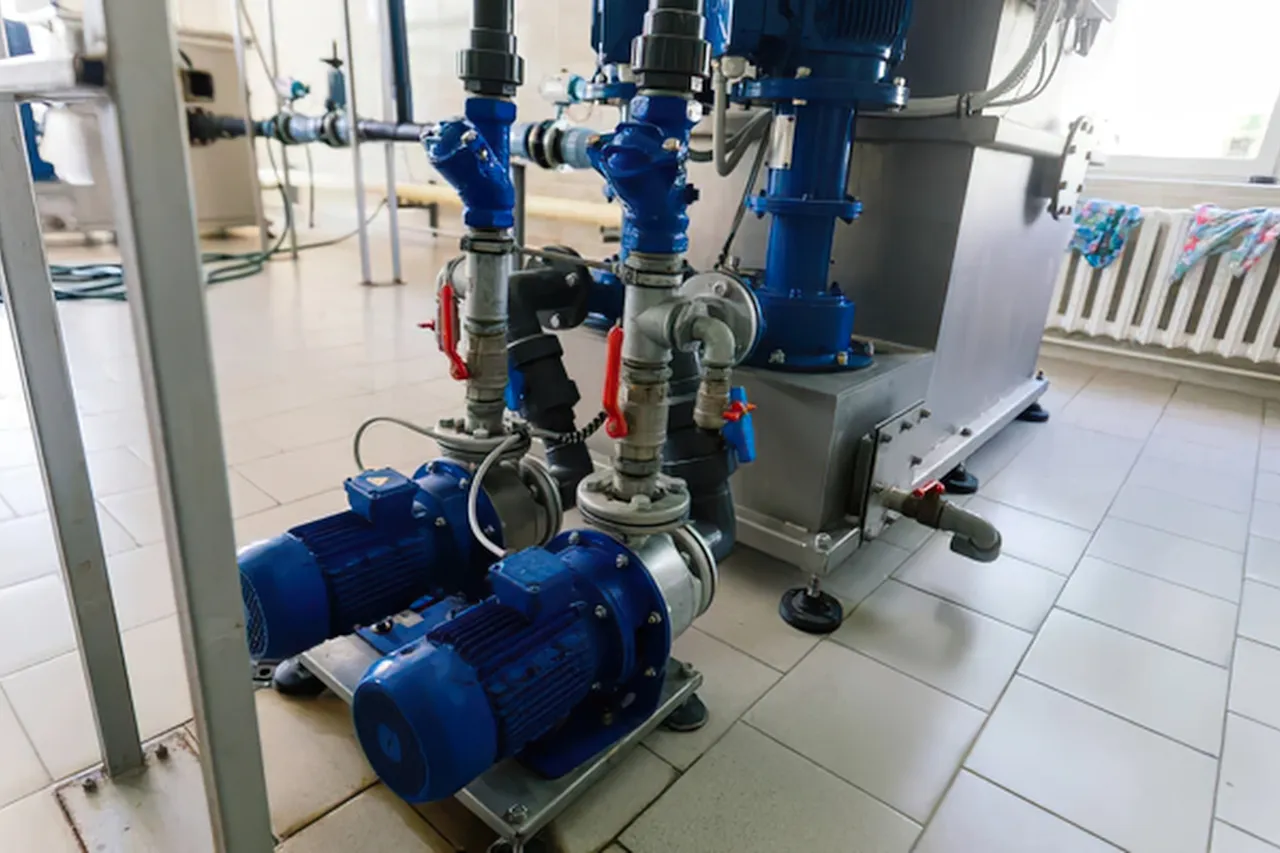 Pompe industriali blu collegate a serbatoio e tubazioni