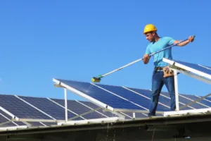 Tecnico pulisce pannelli solari su un tetto