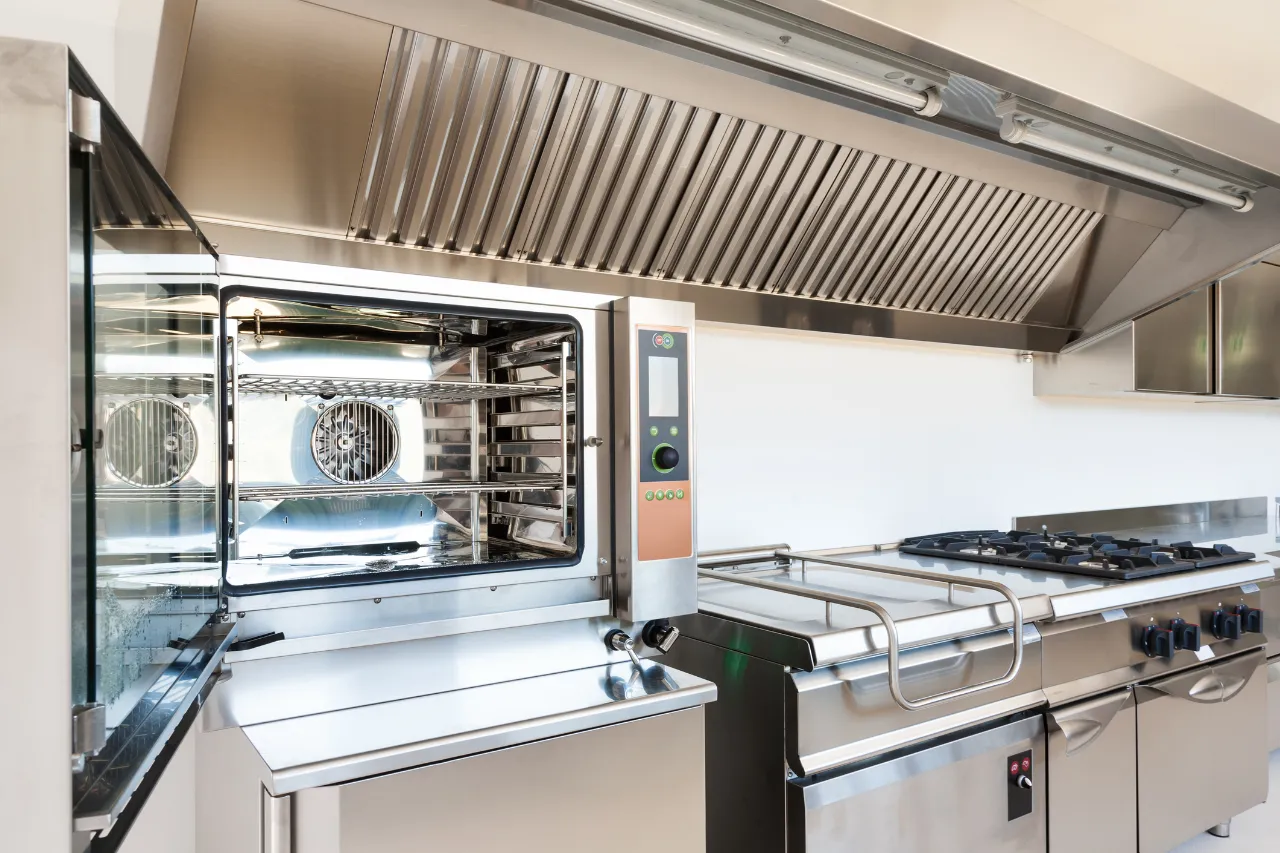 Cucina professionale con forno, fornelli e cappa in acciaio
