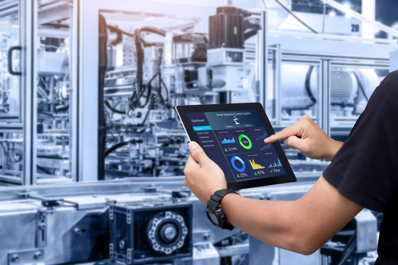 Tecnico controlla dashboard industriale su tablet in fabbrica