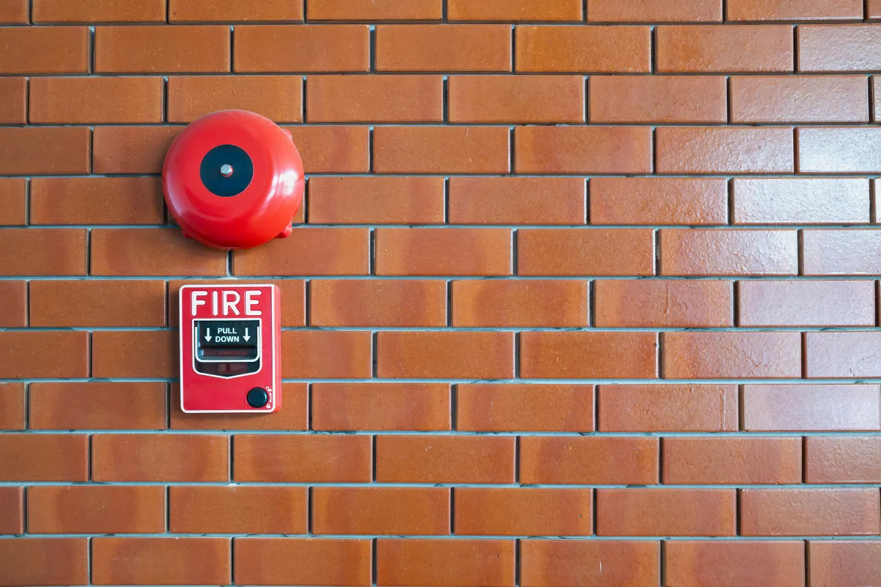 Allarme antincendio e campanello rosso su muro di mattoni