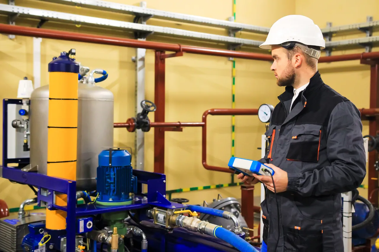 Tecnico controlla impianto industriale con dispositivo elettronico